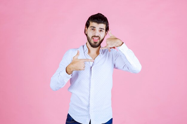 Uomo in camicia bianca che chiede una chiamata.