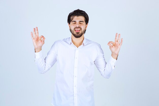 Uomo in camicia bianca che fa meditazione