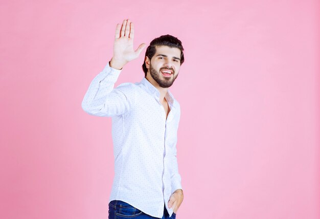 Uomo in camicia bianca che ferma qualcosa.