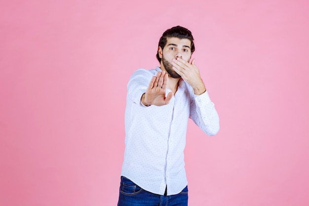 Uomo in camicia bianca che ferma qualcosa.