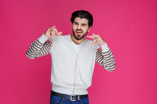 Uomo in camicia bianca che flirta e che fa il segnale di chiamata.