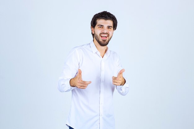 Uomo in camicia bianca che indica il suo collega.