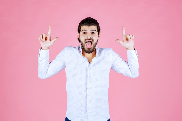 Uomo in camicia bianca che mette fuori la lingua.