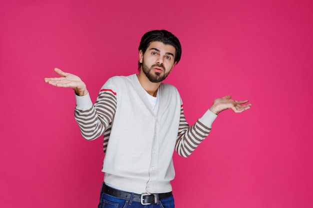 Uomo in camicia bianca che mostra di non avere idea dell'argomento.