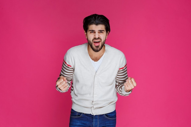 Uomo in camicia bianca che mostra i suoi pugni e il potere.