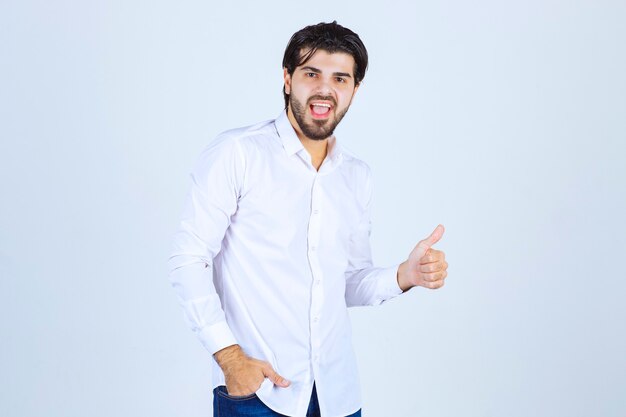 Uomo in camicia bianca che mostra il segno della mano di piacere