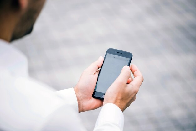 Uomo in camicia che tiene smartphone