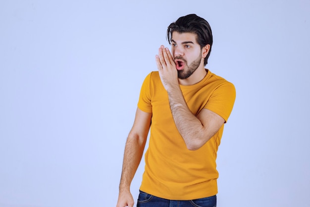 Uomo in camicia gialla che fa pettegolezzi.