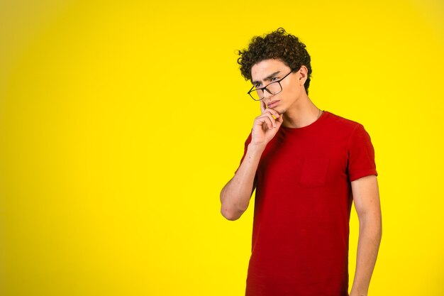 Uomo in camicia rossa che guarda avanti e cerca di ricordare.