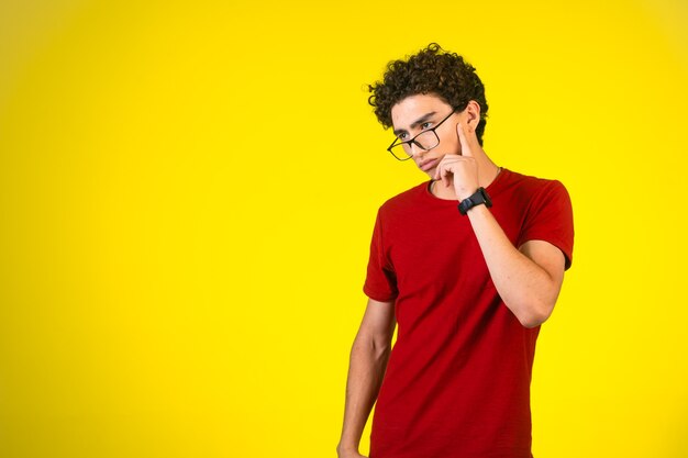 Uomo in camicia rossa che guarda avanti e pensa.