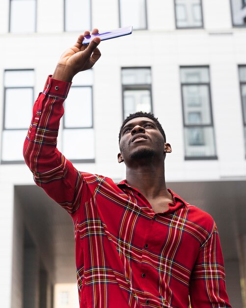 Uomo in camicia rossa che prende un selfie