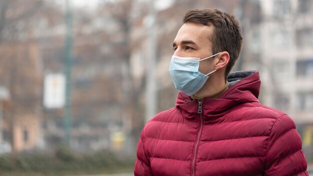 Uomo in città che indossa la mascherina medica