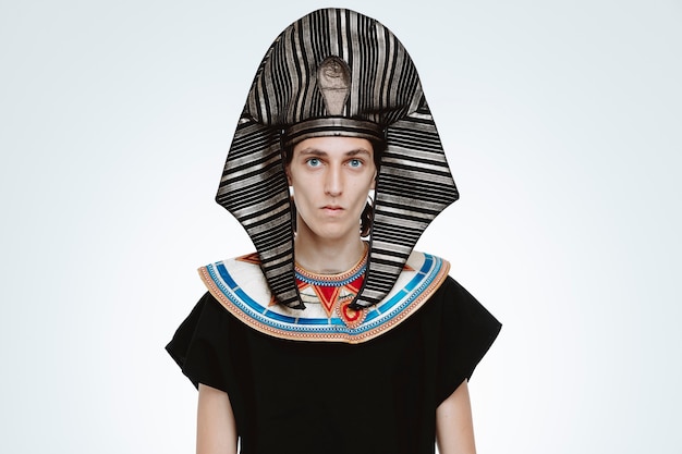Uomo in costume egiziano antico con espressione fiduciosa seria su bianco