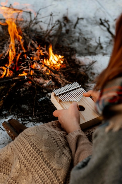 Uomo in fase di riscaldamento accanto a un falò in inverno