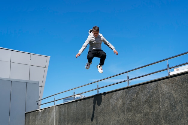 Uomo in forma a figura intera che fa addestramento al parkour