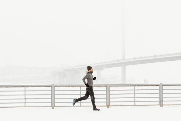 Uomo in forma di colpo pieno che corre da solo