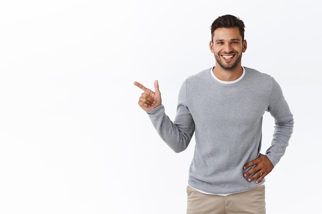 uomo in maglione grigio, parlando delle caratteristiche del prodotto, suggerire un posto dove prendere una tazza di caffè, sedersi e parlare con un amico che ha incontrato per strada, in piedi gioioso