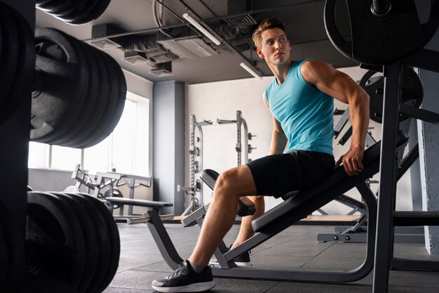 Uomo in palestra che fa esercizi di body building