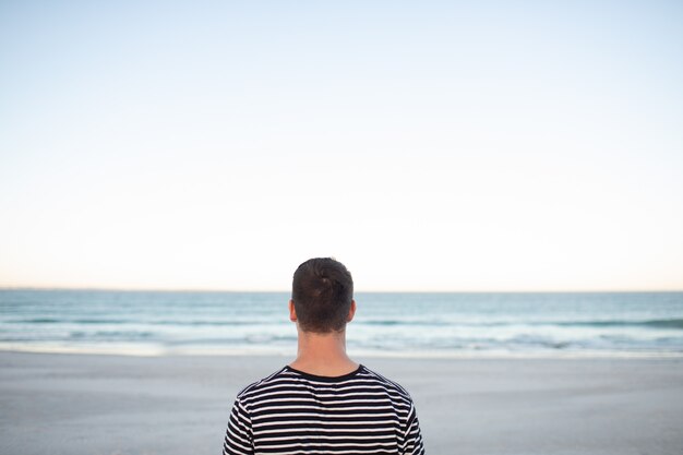 Uomo in piedi sulla spiaggia