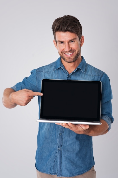 uomo in posa con camicia di jeans e laptop