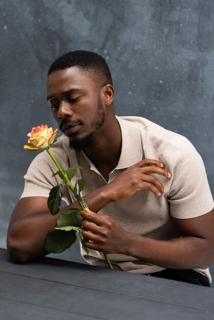 Uomo in posa con un bel fiore medio colpo