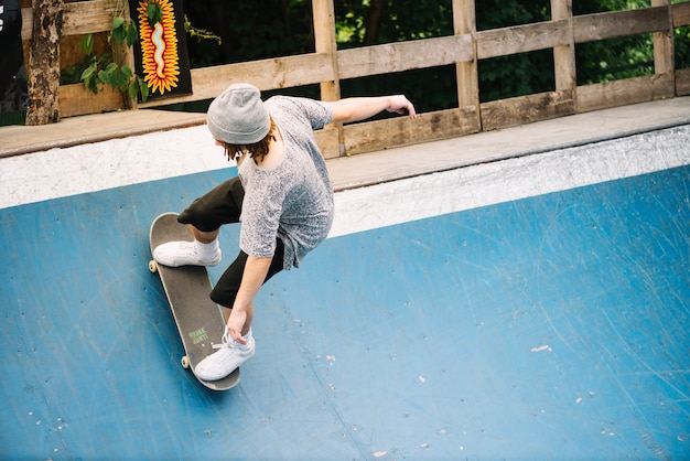 Uomo in sella a skateboard sulla rampa