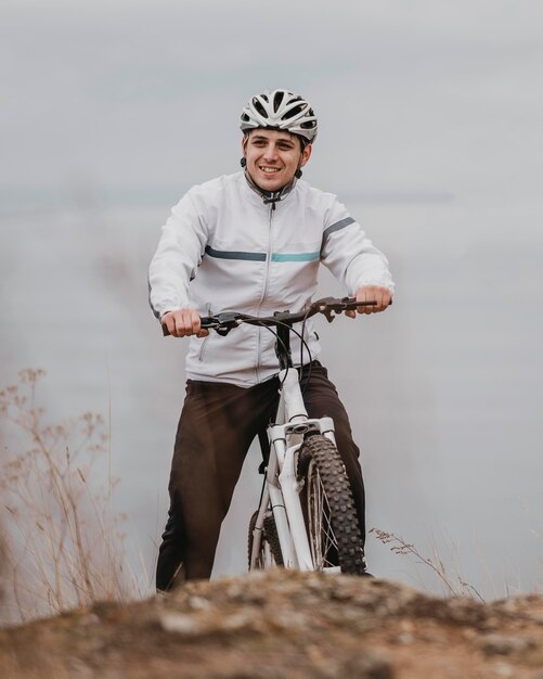 Uomo in sella a una bicicletta in una giornata fredda