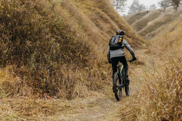 Uomo in sella a una bicicletta sul sentiero di montagna