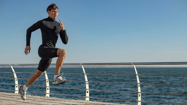 Uomo in spiaggia a fare jogging in abbigliamento sportivo