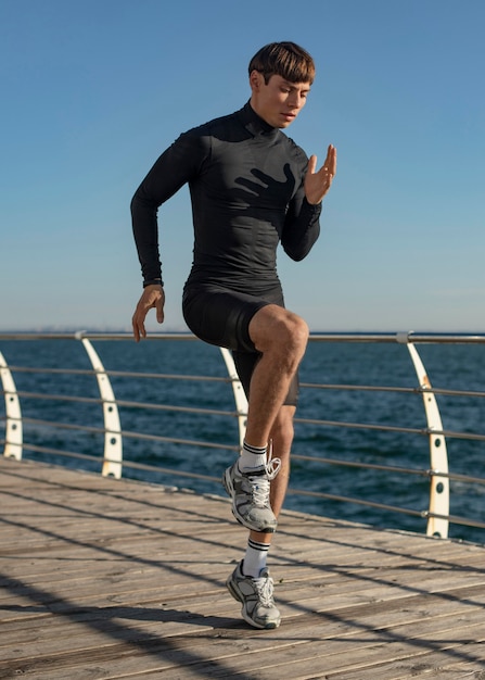 Uomo in spiaggia che lavora in abbigliamento sportivo