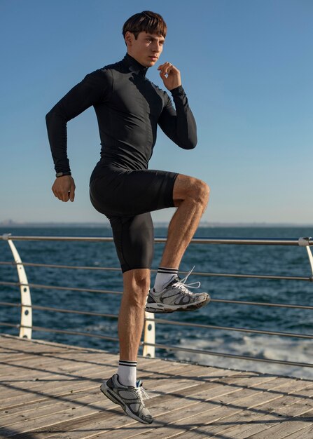 Uomo in spiaggia formazione in abbigliamento sportivo