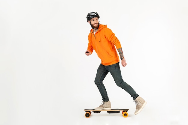Uomo in stile giovane hipster che fa skateboard su skateboard elettrico
