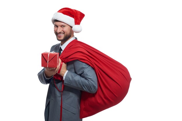 Uomo in suite grigia come Babbo Natale che dà una scatola con un regalo