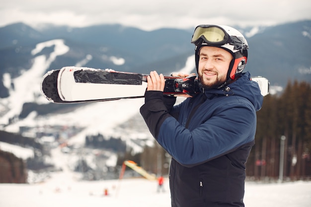 Uomo in tuta da snowboard. Sportivo su una montagna con uno snowboard in mano all'orizzonte. Concetto di sport