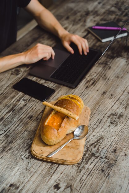 uomo in un caffè che lavora con un computer portatile, mangiare, lavorare, smartphone