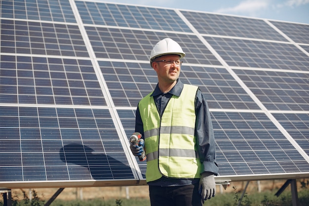 Uomo in un casco bianco vicino ad un pannello solare