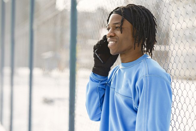 Uomo in un parco invernale. Ragazzo africano che si allena fuori.