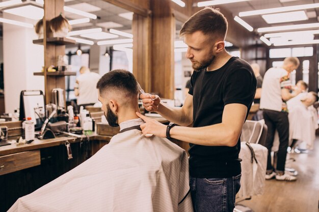 Uomo in un salone di barbiere facendo taglio di capelli e taglio della barba