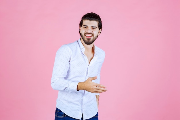 Uomo in una camicia bianca che dà pose neutre e accattivanti.