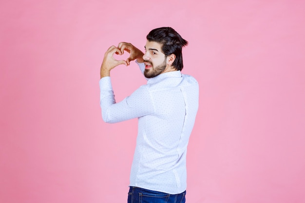 Uomo in una camicia bianca che dà pose sorridenti e positive.