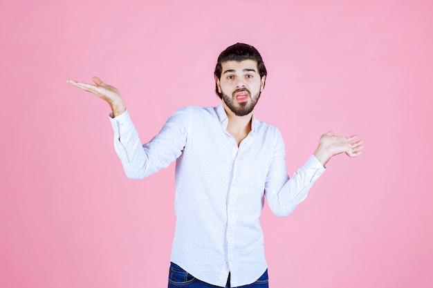 Uomo in una camicia bianca che indica entrambi i lati.