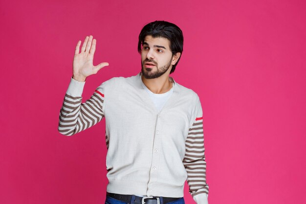 Uomo in una camicia bianca che mostra qualcosa in mano.