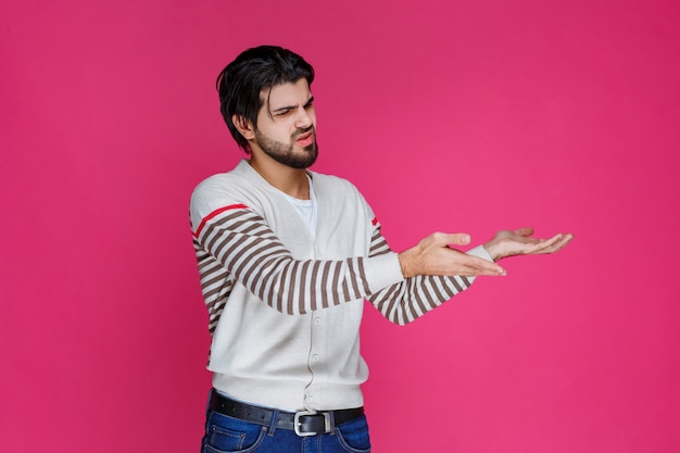 Uomo in una camicia bianca che mostra qualcosa in mano.