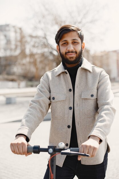 Uomo indiano che guida uno scooter elettrico.