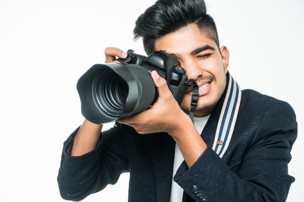 Uomo indiano del fotografo che tiene la sua macchina fotografica su un fondo bianco.