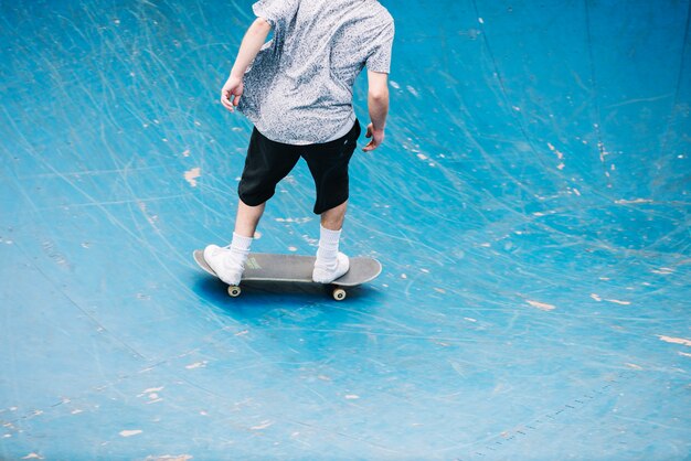 Uomo irriconoscibile che prende corsa in skatepark