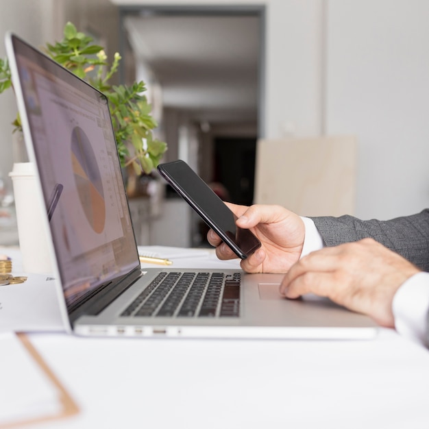 Uomo lateralmente che lavora al suo computer portatile