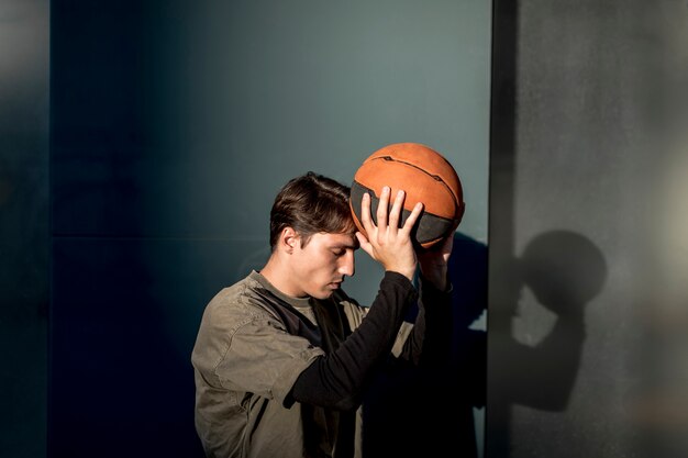 Uomo lateralmente in possesso di un pallone da basket