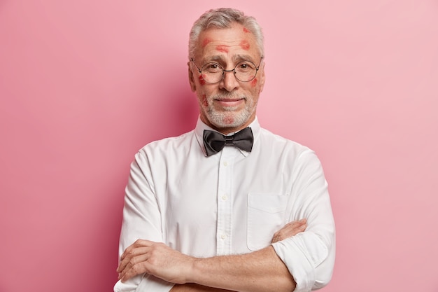 Uomo maggiore che ha macchie di rossetto sul viso