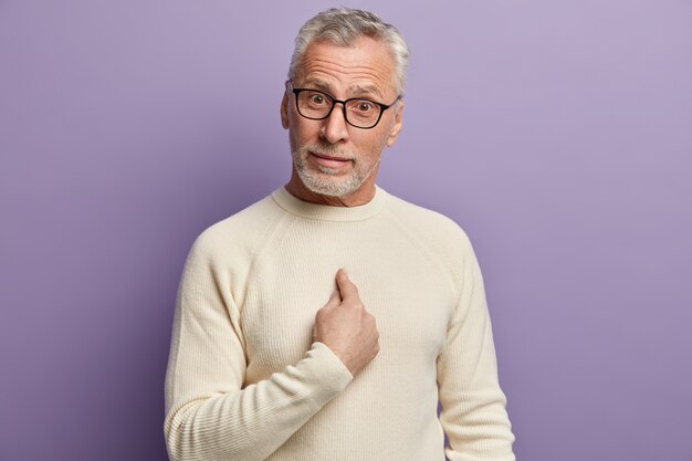 Uomo maggiore che indossa un maglione bianco e occhiali da vista alla moda